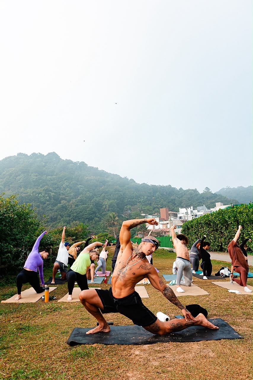 Prática de yoga em campo aberto com montanhas ao fundo