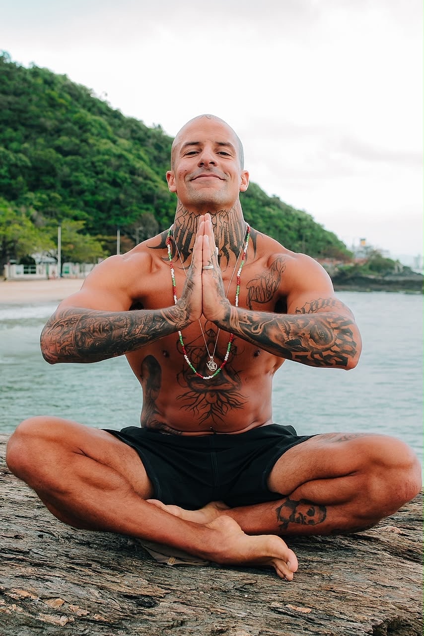 Murilo meditando sobre uma pedra à beira-mar